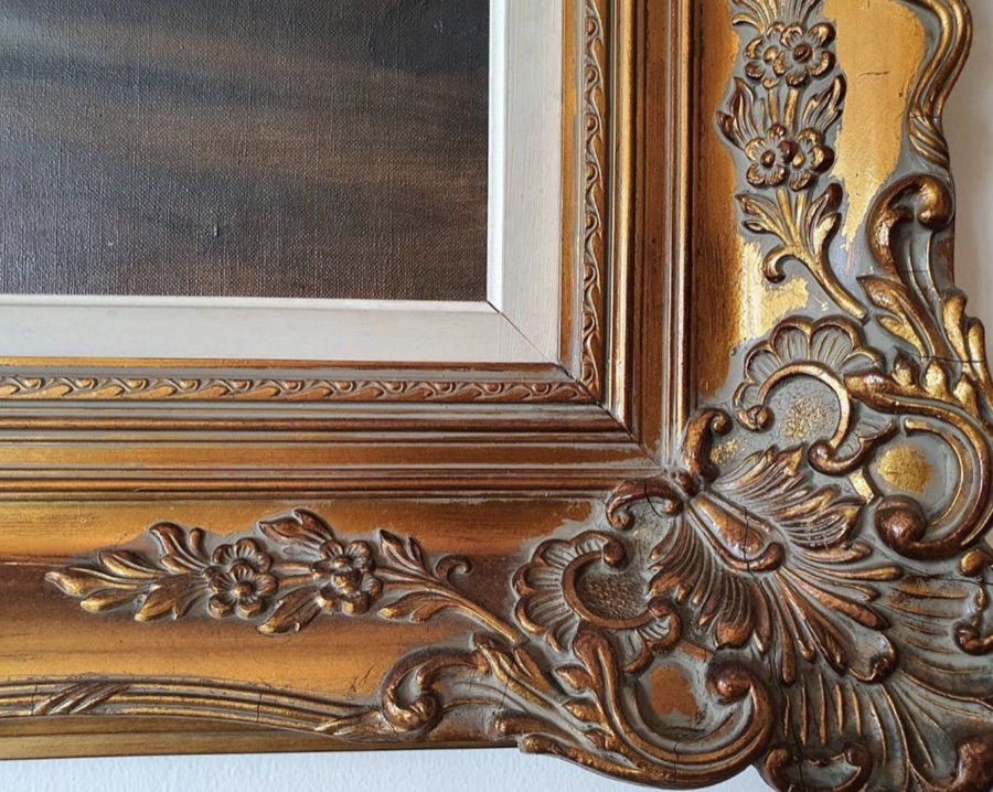 Close-up corner of a hand-carved wood Louis frame with floral motifs